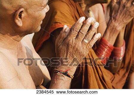 Stock Photography - Hindu man with shaved head during a religious service on the banks of the River Ganges; Uttar Pradesh State, India. Fotosearch