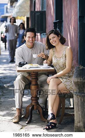 Stock Photography - Hispanic Couple Enjoying Coffee At Cafe On Sidewalk.. Fotosearch