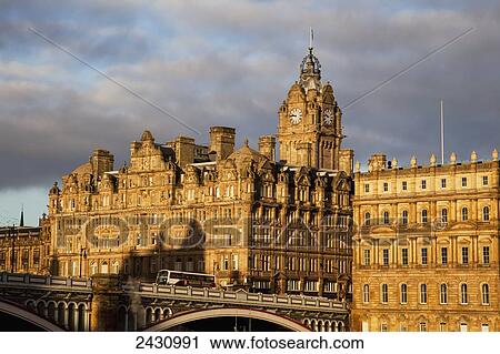 Stock Image - Historic buildings and clock tower against cloudy sky; Edinburgh, Scotland. Fotosearch