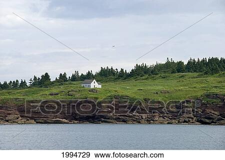Stock Photo - Historic House On An Island As Viewed From The Sea; Perce Quebec Canada. Fotosearch