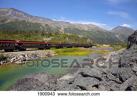 Stock Image - Historic Train Travels Through White Pass Trail; Skagway, Alaska, United States Of America. Fotosearch