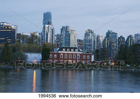 Stock Photograph - Hmcs Discovery On Deadman's Island By Stanley Park With Downtown Buildings In The Background At Dusk, Vancouver, British Columbia, Canada. Fotosearch