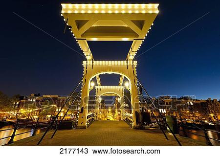 Stock Image - Holland, Magere Brug or Skinny Bridge at dusk; Amsterdam. Fotosearch