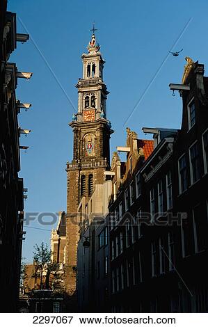 Stock Photo - Holland, View of traditional gabled houses and Oude Lutherse Kerk at dusk; Amsterdam. Fotosearch