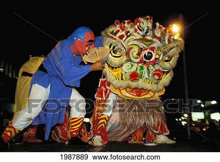 Hong Kong, Chinese New Year, Lion Dance At Night, Man In Costume Whispers In Dragons Ear No Model Release View Large Photo Image Stock Photo - Hong Kong, Chinese New Year, Lion Dance At Night, Man In Costume Whispers In Dragons Ear No Model Release. Fotosearch