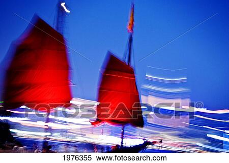 Stock Photography - Hong Kong, Tsim Sha Tsui K, A Red Sailed Chinese Junk Boat Passes In Front Of Hong Kong Island.. Fotosearch
