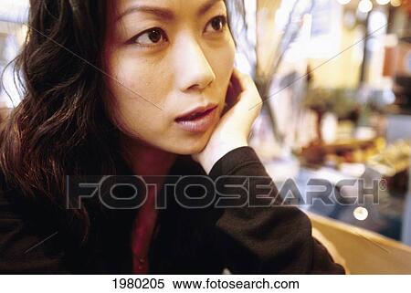 Stock Photography - Hong Kong, Woman Sitting In Local Cafe, Close-Up Of Face Rested On Hand.. Fotosearch