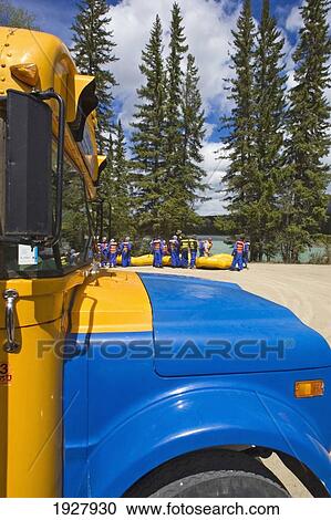 Stock Image - Hood Of School Bus On Rural Parking Lot, Athabasca River, Jasper National Park, Canada. Fotosearch