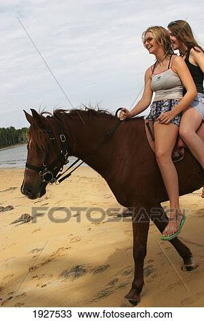 Stock Image - Horse Riding On The Beach. Fotosearch