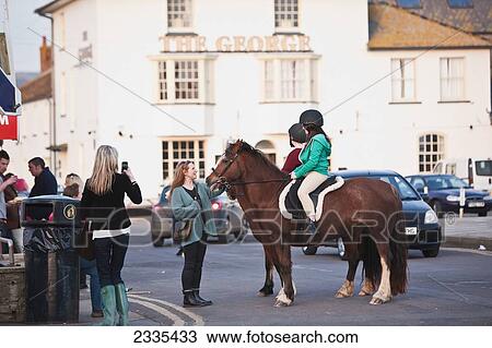 Stock Image - Horse Standing In Street; West Bay, Jurassic Coast, Dorset, England. Fotosearch