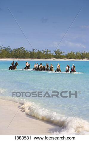 Stock Image - Horseback Riding In The Caribbean Sea; Bahamas. Fotosearch