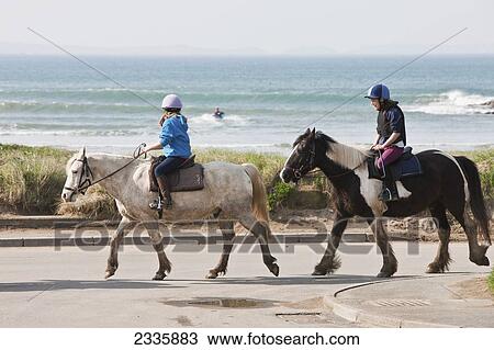 Stock Image - Horses And Riders; Nolton Haven, Pembrokeshire Coast Path, Wales, United Kingdom. Fotosearch