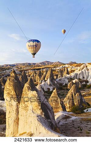 Stock Image - Hot air balloons over the fairy chimneys and rugged landscape; Goreme, Cappadocia, Turkey. Fotosearch