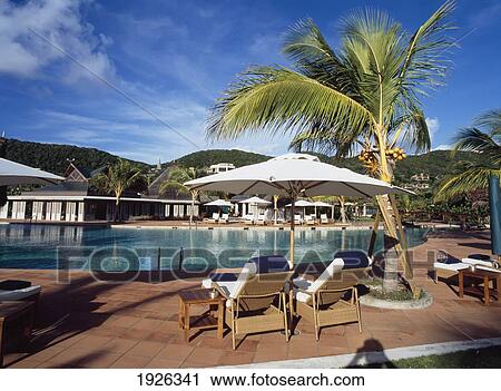 Stock Image - Hotel Swimming Pool With Sunlounger. Fotosearch