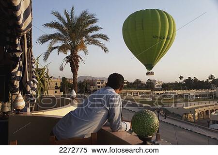 Hotel worker watching hot air balloon from hotel balcony; west bank luxor upper egypt View Large Photo Image Stock Photography - Hotel worker watching hot air balloon from hotel balcony; west bank luxor upper egypt. Fotosearch