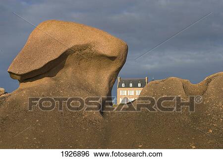 Stock Photograph - House Behind Strangely Shaped Rocks Of The Cote De Granit Rose, Ploumanach, Brittany, France. Fotosearch