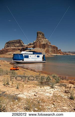 Stock Image - Houseboat Moored On Lake Powell With Kayak; Page Arizona Usa. Fotosearch