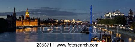 Stock Image - Houses of Parliament and London Eye at dusk; London, England. Fotosearch