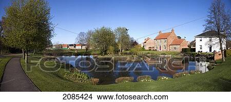 Picture - Houses Reflected In A Tranquil Pond; East Witton Yorkshire England. Fotosearch