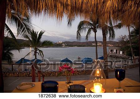 Huatluco, Mexico; An Outdoor Dining Room Looking Over The Beach And Water At Sunset At Las Brisas Resort View Large Photo Image Stock Photo - Huatluco, Mexico; An Outdoor Dining Room Looking Over The Beach And Water At Sunset At Las Brisas Resort. Fotosearch