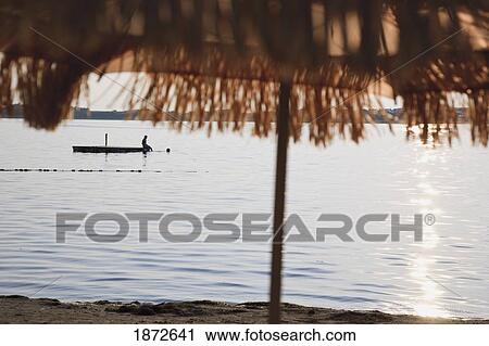 Stock Image - Huatluco, Mexico; Two People In The Water At A Floating Dock Off The Beach At Las Brisas Resort. Fotosearch