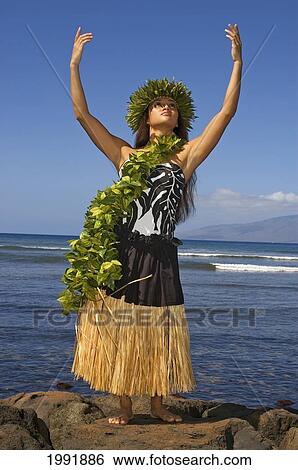 Hula Dancer With Haku Lei In Traditional Outfit On Rocky Coast, Ocean Background View Large Photo Image Stock Photograph - Hula Dancer With Haku Lei In Traditional Outfit On Rocky Coast, Ocean Background. Fotosearch