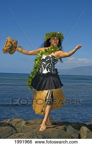 Hula Dancer With Haku Lei In Traditional Outfit On Rocky Coast Holding Uli Uli, Ocean Background View Large Photo Image Stock Photograph - Hula Dancer With Haku Lei In Traditional Outfit On Rocky Coast Holding Uli Uli, Ocean Background. Fotosearch