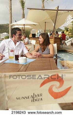 Stock Image - Ibiza, Couple at Sun Sea Bar; San Antonio. Fotosearch