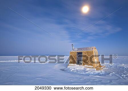 Stock Image - Ice Fishing Hut Under Moonlight On Frozen Lake Winnipeg, Gimli, Manitoba. Fotosearch