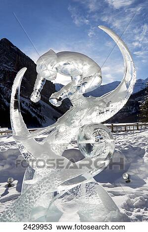 Ice sculpture of down hill skiier with mountain background and blue sky and clouds; Lake Louise, Alberta, Canada View Large Photo Image Stock Image - Ice sculpture of down hill skiier with mountain background and blue sky and clouds; Lake Louise, Alberta, Canada. Fotosearch