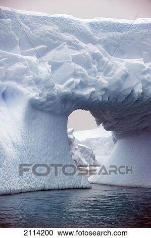 Stock Image - Iceberg With A Hole Through It; Antarctica. Fotosearch