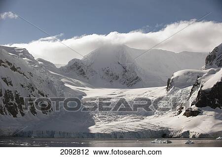 Stock Image - Icebergs And Glaciers On The Mountains Along The Coastline; Antarctica. Fotosearch