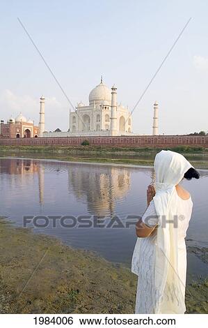 Stock Photograph - India, Agra, Hindu Woman Wearing Sari And Viel Standing Before The Taj Mahal.. Fotosearch