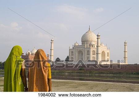 Stock Image - India, Agra, Hindu Women Wearing Colorful Sari And Viels Looking At The Taj Mahal.. Fotosearch