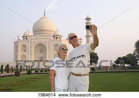 Picture - India, Agra, Tourist Couple Taking Photo Of Themselves In Front Of The Taj Mahal.. Fotosearch
