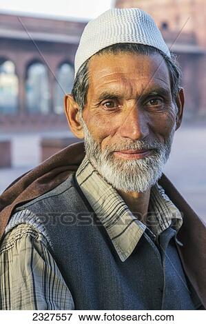 Stock Photo - India, Delhi, Portrait of Muslim man with Kashmir at Jama Masjid in background; New Delhi. Fotosearch