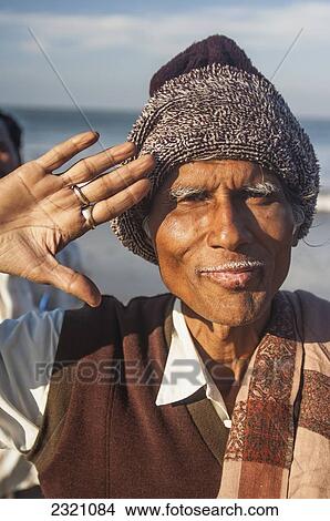 Picture - India, Karnata, Portrait Of Senior Man Saluting On Gokarna Beach; Gokarna. Fotosearch