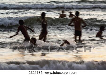Stock Photography - India, Karnataka, Blurry Figures In Crashing Waves At Gokarna Beach; Gokarna. Fotosearch