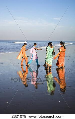 Stock Photo - India, Karnataka, Group Of Indian Teenagers In Bright Clothes On Beach; Gokarna. Fotosearch