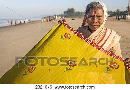 India, Karnataka, Woman Folding Yellow Sari At Beach; Gokarna View Large Photo Image Stock Photograph - India, Karnataka, Woman Folding Yellow Sari At Beach; Gokarna. Fotosearch