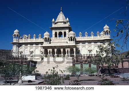 Stock Photograph - India, Mandore Cenotaphs Of Jodhpur Rulers, Exterior Of White Building Against Blue Sky, View From Front.. Fotosearch