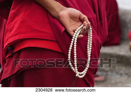 Stock Photo - India, North Sikkim, Detail of Buddhist Monk holding prayer beads during a debating session at Rumtek Monastery; Rumtek Monastery. Fotosearch