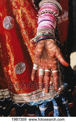 Stock Photo - India, Rajasthan, Close-Up Of Villager Hand Painted With Red Designs, Jewelry And Red Clothing.. Fotosearch