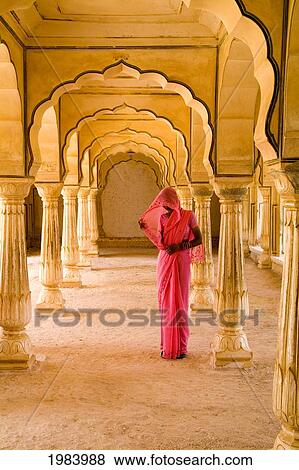 Stock Photo - India, Rajasthan, Jaipur, Amber Fort Temple, Woman In Bright Pink Sari Stands Beneath Arches.. Fotosearch