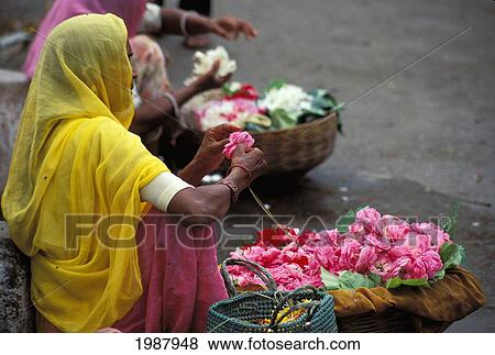 Stock Photo - India, Udaipur, Local Flower Endor Sits On Street Stringing Flower Garland No Model Release. Fotosearch