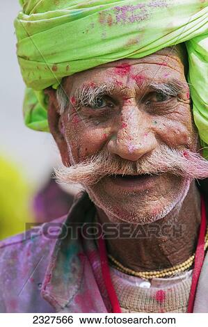 Stock Photograph - India, Uttar Pradesh, along with festive music and dance; Barsana, Portrait of I Hindu man celebrating Lath Mar Holi in small town of Barsana. Holi invloves throwing of colored paints and dyes. Fotosearch