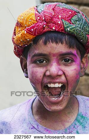 Stock Photo - India, Uttar Pradesh, Portrait of Hindu boy at Lathmar Holi. Holi is celebrated on first day afetr full moon in early March; Barsana. Fotosearch