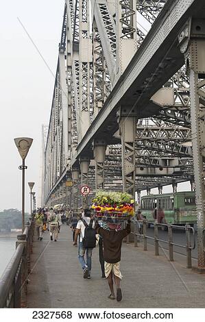 Stock Photo - India, West Bengal, View of people crossing Howrah Bridge; Kolcutta. Fotosearch