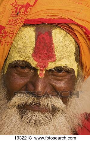 Stock Photo - Indian Hindu sadhu holy man on the steps of the bathing ghats overlooking the sacred but polluted River Ganges. The culture of Varanasi is closely associated with the River Ganges and the river's religious importance. It is the religious capital of India. Fotosearch