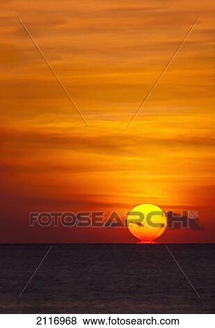 Stock Photo - Indonesia, Bali, A fiery sunset over open waters.. Fotosearch